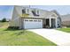 A cozy single-Gathering home boasts a two-car garage, stone accents, and a beautiful lawn at 769 Ashley Woods Dr, Gibsonville, NC 27249