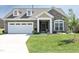 Charming single-Gathering home featuring a stone facade, dormer windows, and a well-manicured lawn at 769 Ashley Woods Dr, Gibsonville, NC 27249