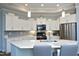 Bright kitchen features white cabinets, stainless appliances, gray backsplash, and a large island with seating at 769 Ashley Woods Dr, Gibsonville, NC 27249