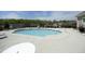 Outdoor community pool with lounge chairs and tables surrounded by a black fence at 769 Ashley Woods Dr, Gibsonville, NC 27249