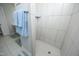 Modern tiled shower with a built-in shelf and a herringbone tile floor at 769 Ashley Woods Dr, Gibsonville, NC 27249