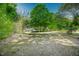 Lush backyard with mature trees offering privacy and a picturesque view of the home's exterior at 7955 Midnight Ln, Wake Forest, NC 27587