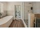 Luxurious bathroom with a freestanding tub, a glass-enclosed shower and chic gray tiling at 7955 Midnight Ln, Wake Forest, NC 27587