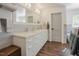 Modern bathroom showcasing dual sinks, sleek white cabinetry, and warm wood-look flooring at 7955 Midnight Ln, Wake Forest, NC 27587