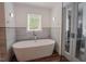 Bright bathroom with a soaking tub and an open shower area with updated fixtures and finishes at 7955 Midnight Ln, Wake Forest, NC 27587
