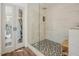 Stylish bathroom boasts a walk-in glass shower with sleek fixtures and decorative gray tile floors at 7955 Midnight Ln, Wake Forest, NC 27587