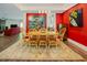 Elegant dining room with a wooden table and chairs, complemented by red accent walls and natural light at 7955 Midnight Ln, Wake Forest, NC 27587