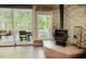 Stone fireplace offering ample light with sliding glass doors to the outside patio and wood burning stove at 7955 Midnight Ln, Wake Forest, NC 27587