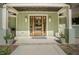 Welcoming front entryway featuring a wooden door with sidelights, elegant lighting, and a covered porch at 7955 Midnight Ln, Wake Forest, NC 27587
