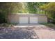 Detached two car garage with adjacent covered parking on a gravel lot, perfect for extra storage at 7955 Midnight Ln, Wake Forest, NC 27587