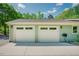 Attached two-car garage with white doors and a convenient hose setup on a sunny day at 7955 Midnight Ln, Wake Forest, NC 27587