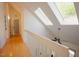 Hallway featuring a white railing and skylights that provide ample natural light at 7955 Midnight Ln, Wake Forest, NC 27587