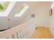 Upstairs hallway with skylights and a ceiling fan, offering natural light and ventilation at 7955 Midnight Ln, Wake Forest, NC 27587