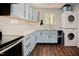 Modern kitchen featuring stainless steel appliances, and stacked laundry at 7955 Midnight Ln, Wake Forest, NC 27587