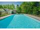 Beautiful backyard pool with mature trees in the background, perfect for summer relaxation and fun at 7955 Midnight Ln, Wake Forest, NC 27587