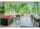 Bright sunroom with floor-to-ceiling windows, comfortable seating, and views of the lush backyard at 7955 Midnight Ln, Wake Forest, NC 27587