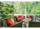 Bright sunroom with lots of potted plants, comfortable seating arrangements, and plenty of natural light at 7955 Midnight Ln, Wake Forest, NC 27587