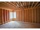 Unfinished bedroom featuring exposed wooden framing and two bright windows at 7961 Wexford Waters Ln, Wake Forest, NC 27587