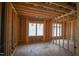Unfinished bedroom featuring exposed wooden framing, electrical wiring, and bright windows at 7961 Wexford Waters Ln, Wake Forest, NC 27587
