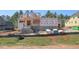 New construction showcases block foundation, Tyvek wrap, wood frame and building progress amidst a verdant landscape at 7961 Wexford Waters Ln, Wake Forest, NC 27587