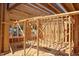 View of house framing shows interior wood beams and window placements in this new home construction at 7961 Wexford Waters Ln, Wake Forest, NC 27587