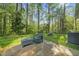 Secluded backyard patio area surrounded by lush trees and greenery, offering a private outdoor space at 8 Bluebell Ct, Durham, NC 27713