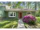 Charming home featuring a well maintained front yard, bay window, and a vibrant red front door at 8 Bluebell Ct, Durham, NC 27713