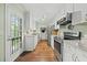 Galley kitchen with stainless steel appliances, white cabinets, neutral countertops, and a door to the outside at 8 Bluebell Ct, Durham, NC 27713