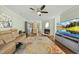 Bright living room with hardwood floors, fireplace, large windows and a ceiling fan at 8 Bluebell Ct, Durham, NC 27713