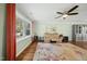 Bright living room with a ceiling fan, hardwood floors, a fireplace and large windows at 8 Bluebell Ct, Durham, NC 27713