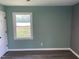 This bedroom has calming blue-green walls, wood floors, and large windows at 83 Brentwood Dr, Selma, NC 27576
