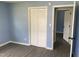 Bedroom features a blue wall and gray floor, equipped with a closet with folding doors and an open doorway at 83 Brentwood Dr, Selma, NC 27576
