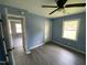 Bedroom has light blue walls, gray floors, a fan, a window, a closet, and doorway leading to another area at 83 Brentwood Dr, Selma, NC 27576