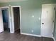 This bedroom has calming blue-green walls, wood floors, and three doorways at 83 Brentwood Dr, Selma, NC 27576