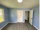 Bedroom features a blue wall and gray floor, equipped with a closet with folding doors and an open doorway at 83 Brentwood Dr, Selma, NC 27576