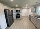 Spacious kitchen featuring modern stainless steel appliances, granite countertops and grey wood flooring at 83 Brentwood Dr, Selma, NC 27576