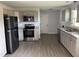 Bright kitchen features stainless steel appliances, granite countertops, white cabinetry and grey wood flooring at 83 Brentwood Dr, Selma, NC 27576