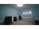 Bedroom with a blue paint job, closet, and window overlooking backyard at 901 Hollymont Dr, Holly Springs, NC 27540