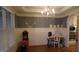 An elegant dining room featuring hardwood floors, wainscoting, chandelier, and adjacent built-in cabinet at 901 Hollymont Dr, Holly Springs, NC 27540