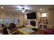 Cozy living room with fireplace, built-in shelving, ceiling fan and large-screen television at 901 Hollymont Dr, Holly Springs, NC 27540
