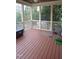 Relaxing screened-in porch with wood flooring, ceiling fan, and views of the serene outdoor landscape at 901 Hollymont Dr, Holly Springs, NC 27540