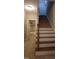Staircase with carpet runner and wood trim leads to the upper level, bedroom visible in background at 901 Hollymont Dr, Holly Springs, NC 27540