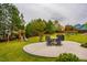 Lush backyard featuring a patio, outdoor seating, a grill, a playground, and mature trees at 91 Cliffdale Rd, Chapel Hill, NC 27516