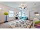 Spacious bedroom with a patterned rug, fan, and play area with a toy shelf and blue futon at 91 Cliffdale Rd, Chapel Hill, NC 27516
