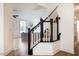 Bright entryway featuring hardwood floors, black and white staircase, and glimpses of a cozy living area at 91 Cliffdale Rd, Chapel Hill, NC 27516