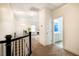 Bright upstairs hallway with carpet, a door leading to the bathroom, and a playroom nearby at 91 Cliffdale Rd, Chapel Hill, NC 27516