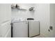 Functional laundry room featuring a white washer, dryer, and overhead shelving for supplies at 91 Cliffdale Rd, Chapel Hill, NC 27516