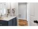 Powder room with a navy vanity, light countertops, and wood flooring at 928 Lily Claire Ln, Fuquay Varina, NC 27526
