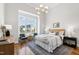 Light-filled bedroom with large window, chandelier and view of the neighborhood at 928 Lily Claire Ln, Fuquay Varina, NC 27526