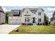 Beautiful two-story home with a well-manicured lawn, attached two car garage, and classic black and white trim at 928 Lily Claire Ln, Fuquay Varina, NC 27526